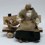 Grossmutter sitzend auf einer Bank inkl. Brotkorb